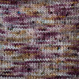 A closeup of a knit swatch of the Queen City colourway. It is a variegated swatch, with colour shifting quickly between grey, wine purple & grey.